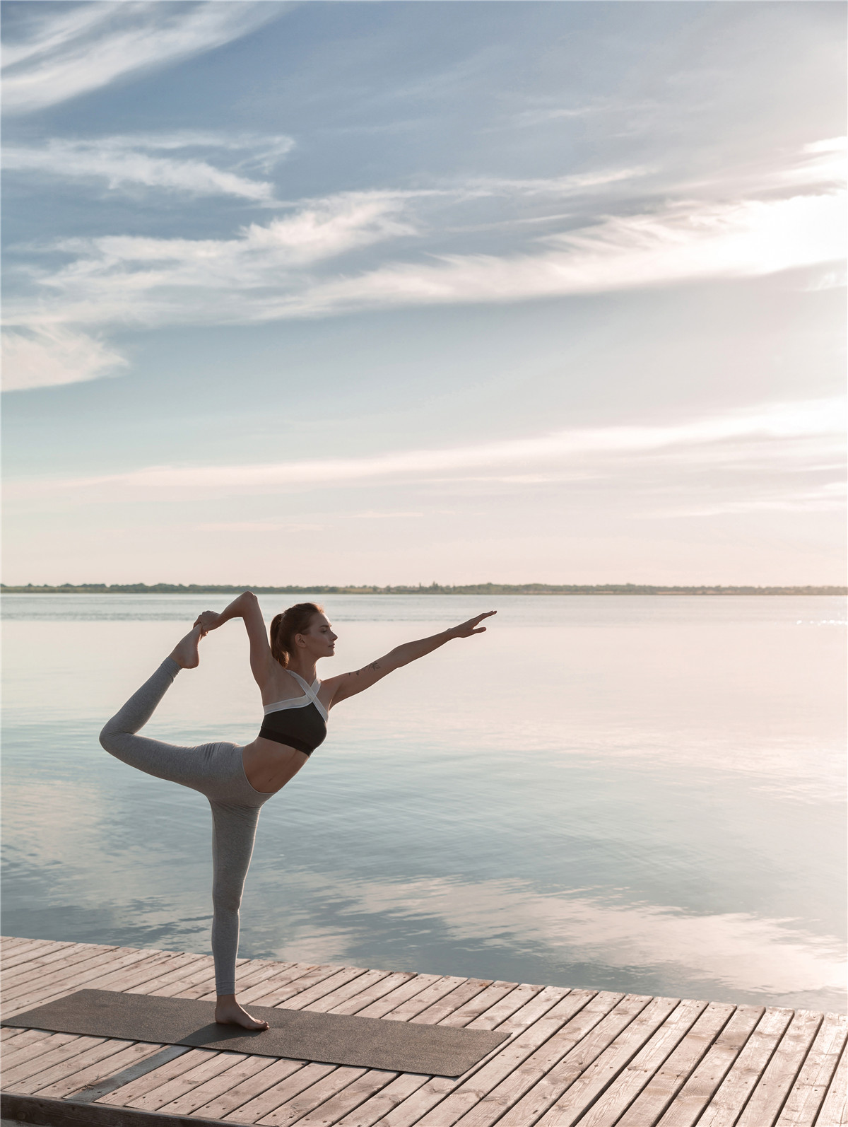sport-dame-staand-strand-make-yoga-oefeningen