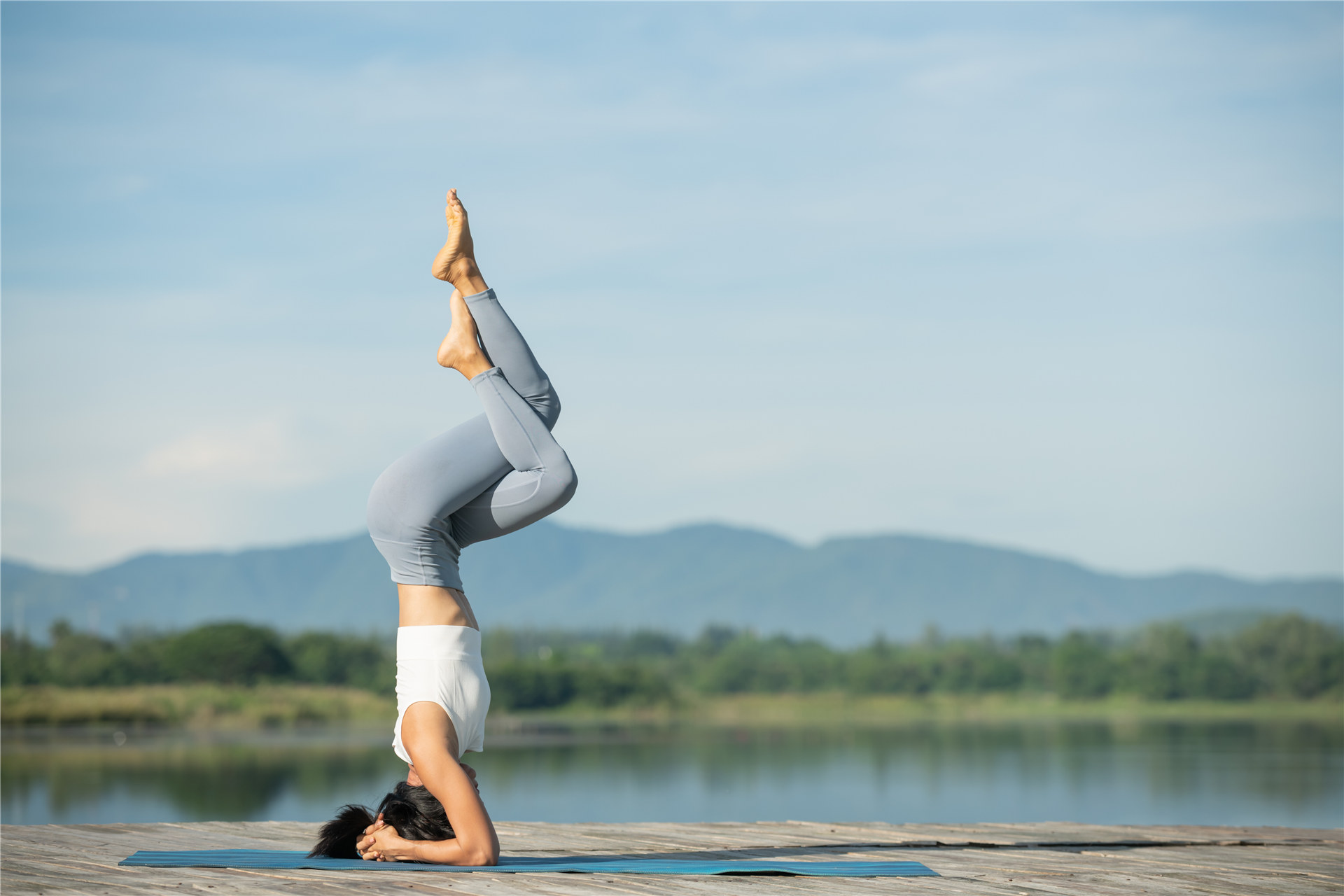 kvinne-yoga-matte-slapp av-park-ung-sporty-asiatisk-kvinne-øver-yoga-gjør-hodestående-trening-trening-bruker-sportsklær-bukser-topp